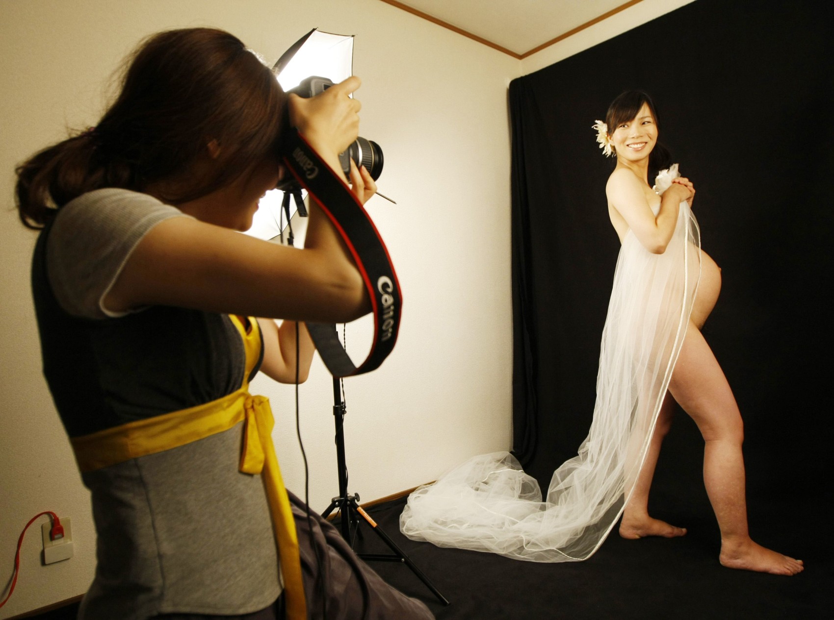 Two pregnant women wearing underwear in a studio, showing their changing  bodies proudly