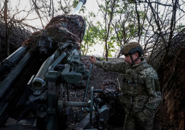 FILE PHOTO: Ukrainian serviceman prepares a howitzer to fire towards Russian troops in Donetsk region
